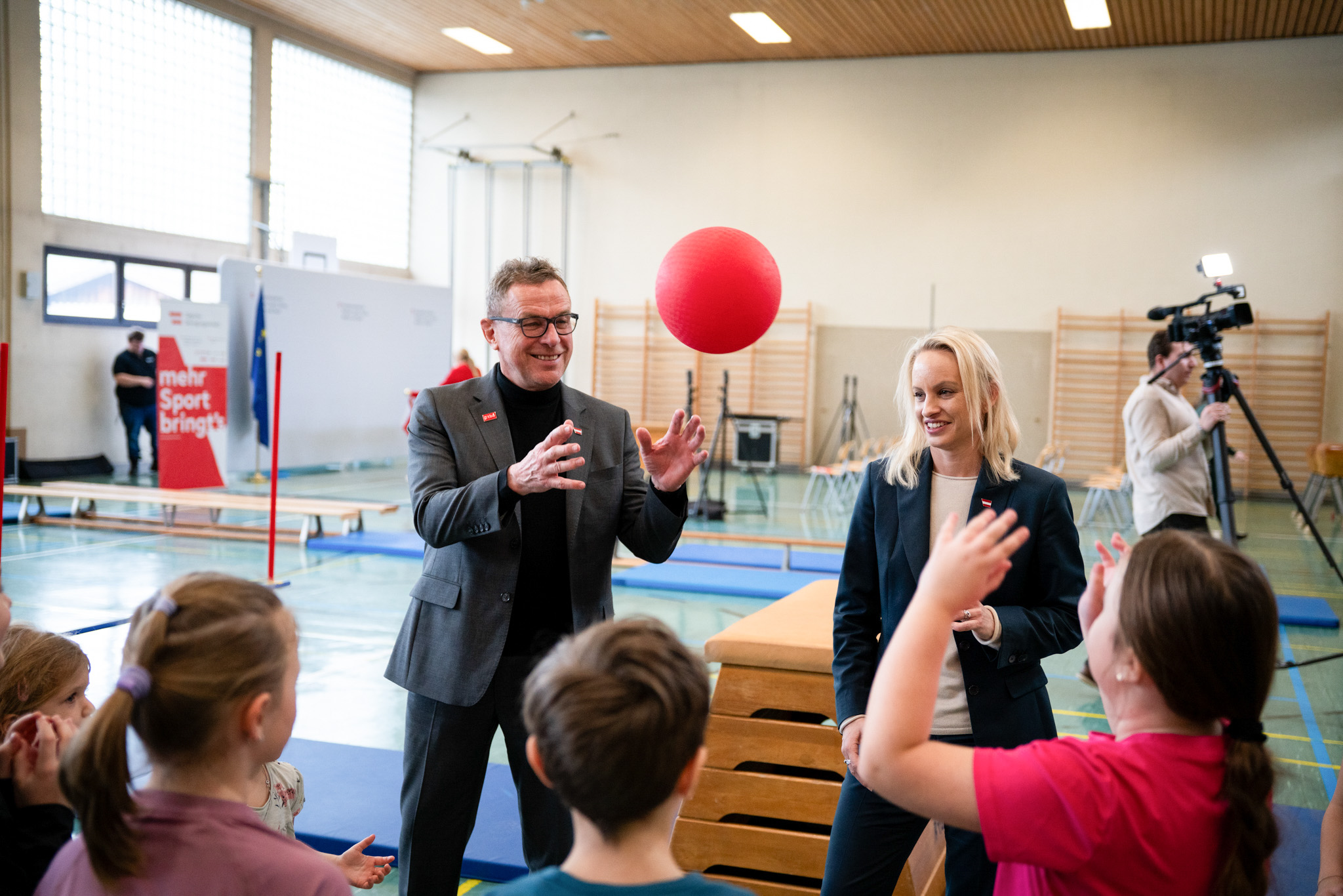 Ralf Rangnick und Sport-Staatssekretärin Michaela Schmidt bei einer Station der Tägliche Bewegungseinheit in der Turnhalle.