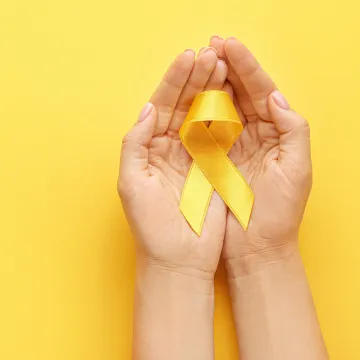 © Pixel-Shot - stock.adobe.com Yellow Ribbon wird in Hand gehalten.