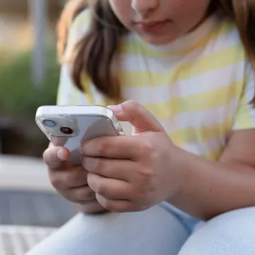 © Larysa - stock.adobe.com Kind oder Jugendliche bedient ein Smartphone.