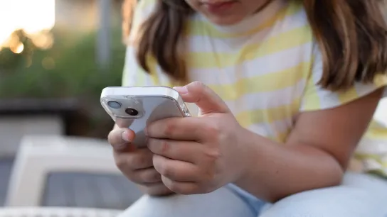 © Larysa - stock.adobe.com Kind oder Jugendliche bedient ein Smartphone.